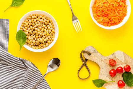Vegetarian meal. Chickpeas and carrot in bowls on table top view.の写真素材