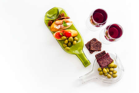Antipasto on glass bottle plate and red wine in glasses top-down copy spaceの写真素材