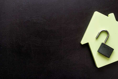 Security concept - lock and house figure - on black desk top-down space of textの写真素材