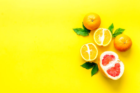 Oranges and grapefruits with leaves on table top view copy space