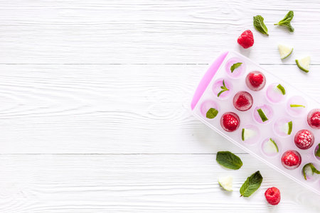 Ice cubes with berries and mint top view copy space