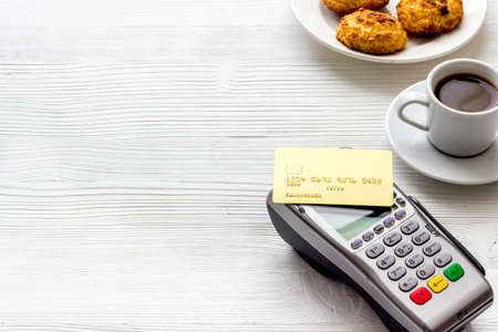 Payment transactions. Terminal and credit card on cafe white table copy spaceの写真素材