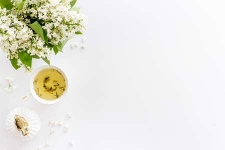 Flat lay of jasmine flowers bouquet with cup tea on workspaceの写真素材