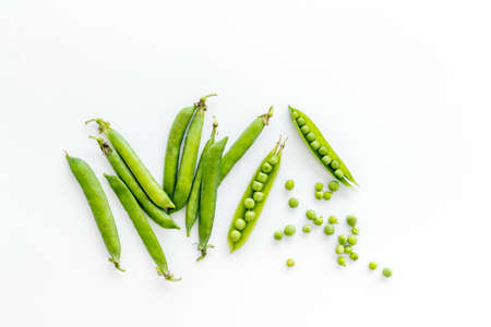 Top view of green pea pods and peas on the kitchen backgroundの写真素材