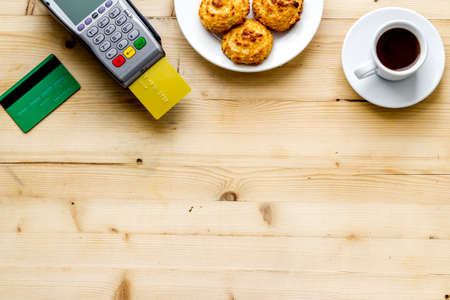 Payment by credit card. Terminal on wooden restaurant desk from above copy spaceの写真素材