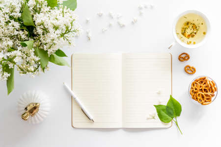 Jasmine flowers bouquet with cup tea and notepad top viewの写真素材