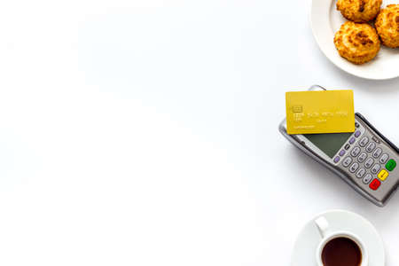 Payment by credit card. Terminal on white restaurant desk from above copy spaceの写真素材