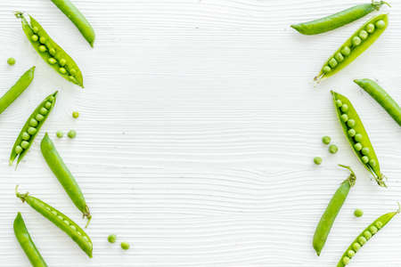 Frame of green pea pods and peas on the kitchen backgroundの写真素材