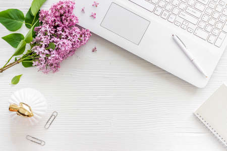 Flat lay office table desk with jasmine flowers bouquet. Workspace with laptopの写真素材