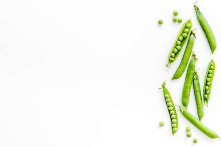 Top view of green pea pods and peas on the kitchen backgroundの写真素材