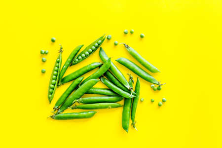 Top view of green pea pods and peas on the kitchen backgroundの写真素材