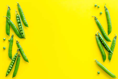 Frame of green pea pods and peas on the kitchen backgroundの写真素材