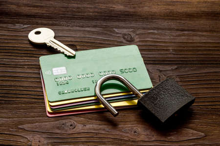 credit card hacked - security lock open - on wooden table top viewの写真素材