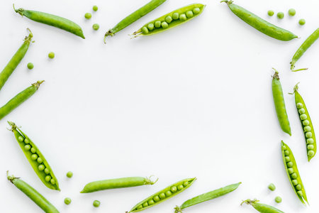 Frame of green pea pods and peas on the kitchen background