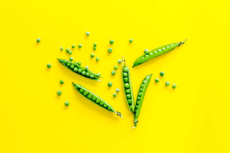 Top view of green pea pods and peas on the kitchen backgroundの写真素材