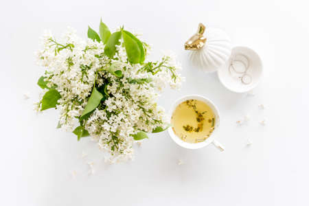 Jasmine flowers bouquet with cup tea and notepad top viewの写真素材