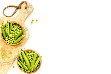 Bowl of green pea pod with beans on kitchen desk. Top view