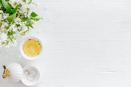 Flat lay of jasmine flowers bouquet with cup tea on workspaceの写真素材