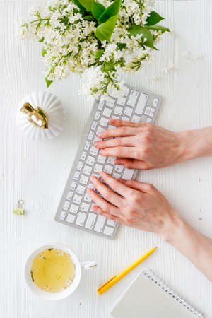 Woman s hands writing on office table desk with flowers. Education conceptの写真素材