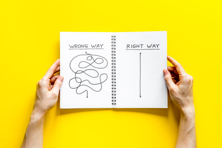 Open notepad with concept of right and wrong strategy - in hands - top view