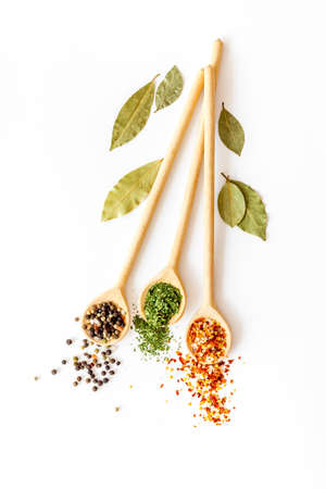 Powder spices in wooden spoons on a kitchen tableの写真素材