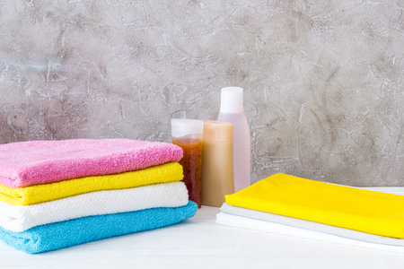 Stack of bath towels and clothes on ironing boardの写真素材