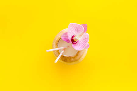 Raw coconut cocktail with drinking straw, top viewの写真素材