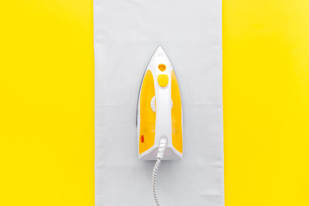 Household laundry ironing concept. Iron with clothes top view