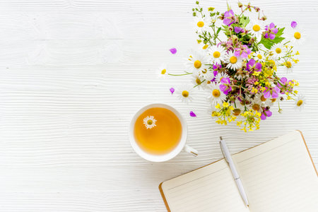 Wild flowers bouquet with cup tea on a table, top viewの写真素材