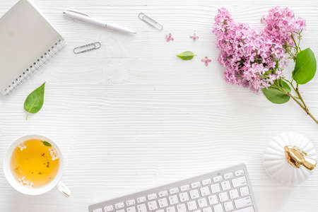 Layout of computer and lilacs flowers on bright working space. Top viewの写真素材