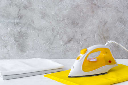 Close up of iron and towels on ironing boardの写真素材