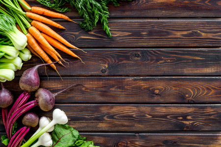 Flat lay of fresh vegetables and greenery on wooden table top-down copy space
