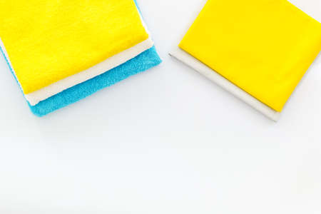 Stack of bath towels and clothes on ironing boardの写真素材