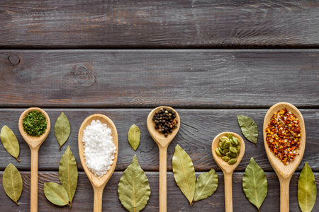 Powder spices in wooden spoons on a kitchen table