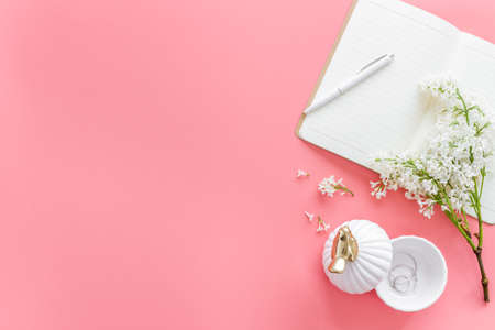 Top view of jasmine flowers bouquet with notebook and cup tea on working placeの写真素材