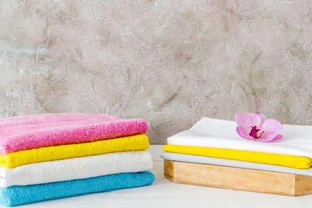 Stack of bath towels and clothes on ironing boardの写真素材