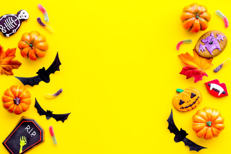 Halloween decoration concept with pumpkins, cookies and autumn leaves, top view