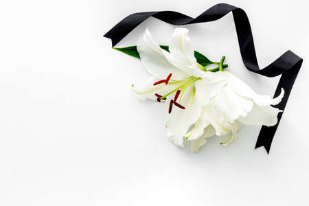 Funeral symbols - white lily flowers with black ribbonの写真素材