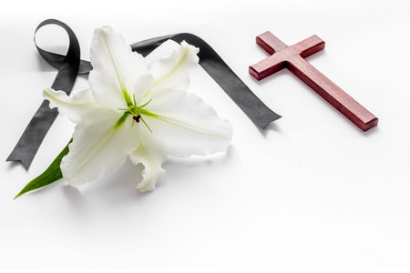 White lily with cross and black ribbon. Funeral concept