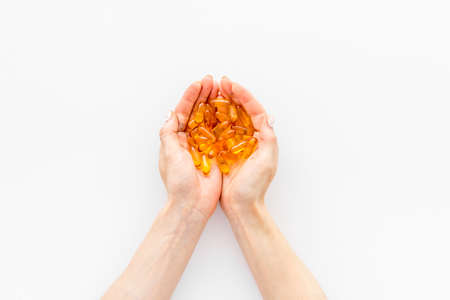 Fish oil omega capsules in hands top view, copy spaceの写真素材