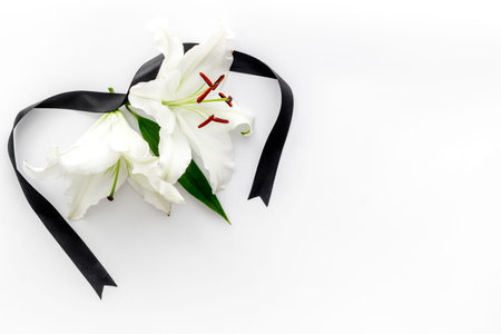 Funeral concept with lily and black ribbon, space for text