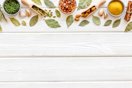 Powder spices in wooden spoons on a kitchen tableの写真素材
