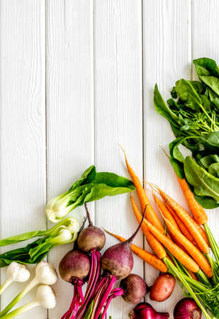 Flat lay of fresh vegetables and greenery on white table top-down copy spaceの写真素材