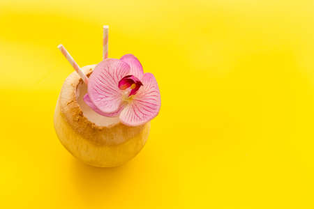 Raw coconut cocktail with drinking straw, top viewの写真素材