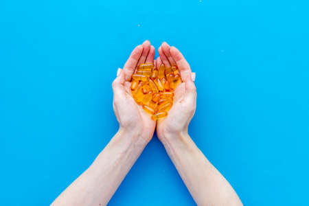 Fish oil omega capsules in hands top view, copy space