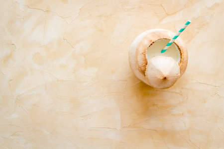 Green coconuts with drinking straw - tropical cocktail, above view