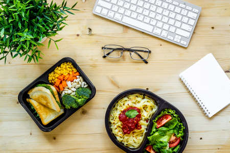 Call for delivery concept. Lunch boxes with meal on working placeの写真素材