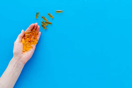 Fish oil omega capsules in hands top view, copy spaceの写真素材