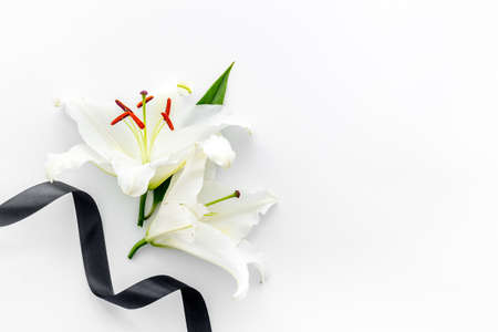 Funeral concept with lily and black ribbon, space for textの写真素材