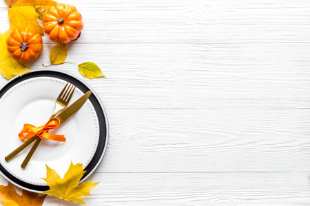 Thanksgiving day dinner table, top view . Autumn vegetables on plate with cutlery
